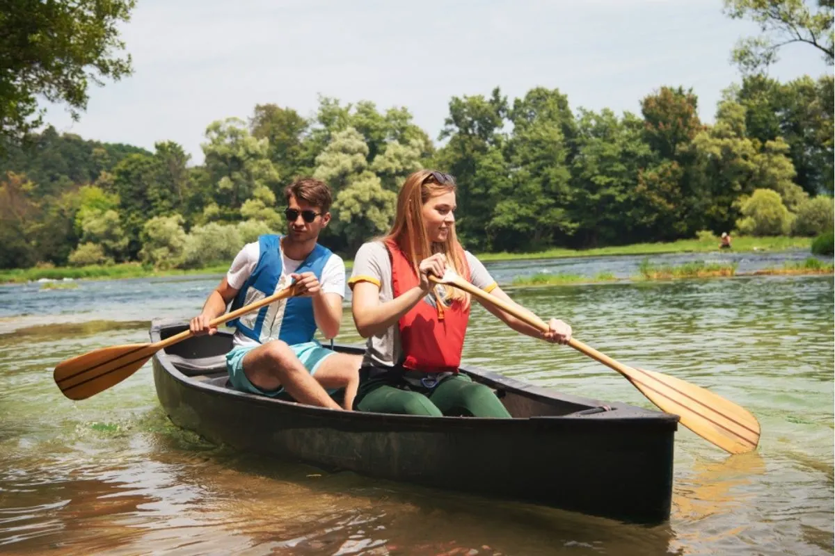 A adventurous couple canoeing in a wild river.