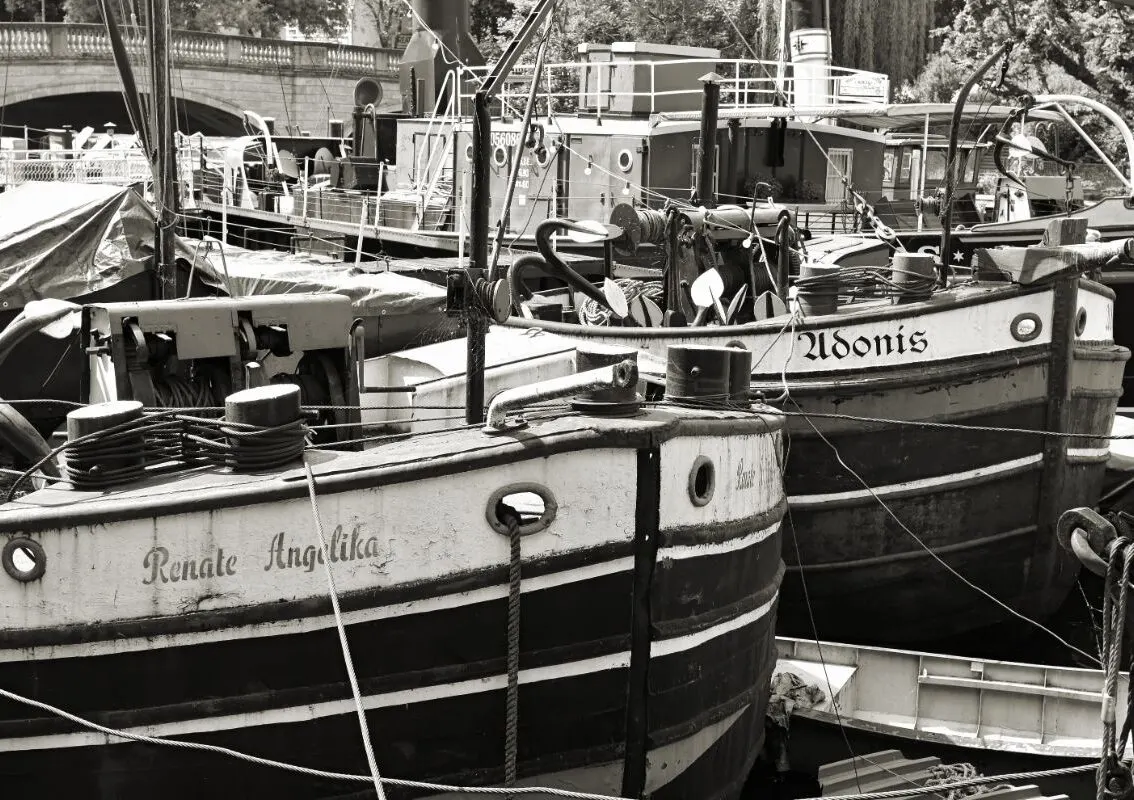 A black and white photo of a old cargo ship with their names painted.