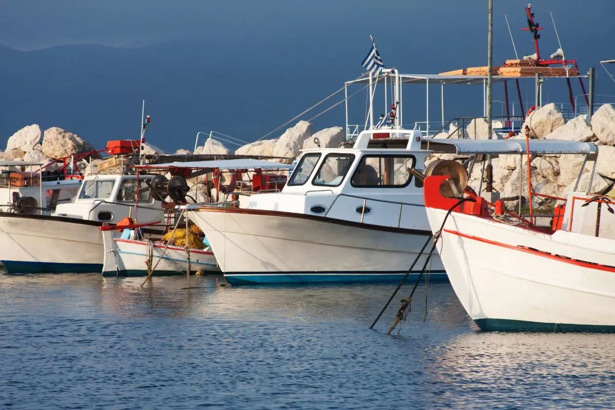 A photo of fishing boats moored in a port.