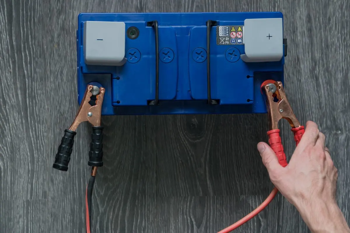 Bluea lead acid battery connected with a cable.