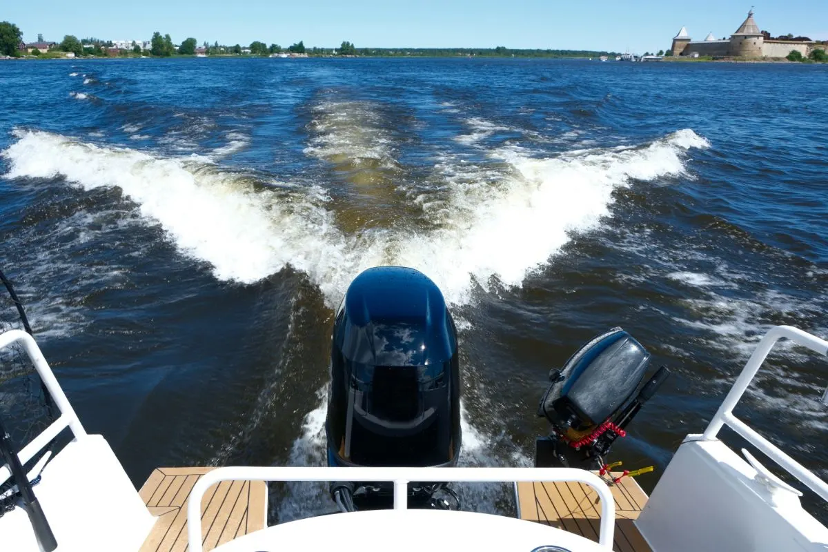 A trail on water behind motor boat.