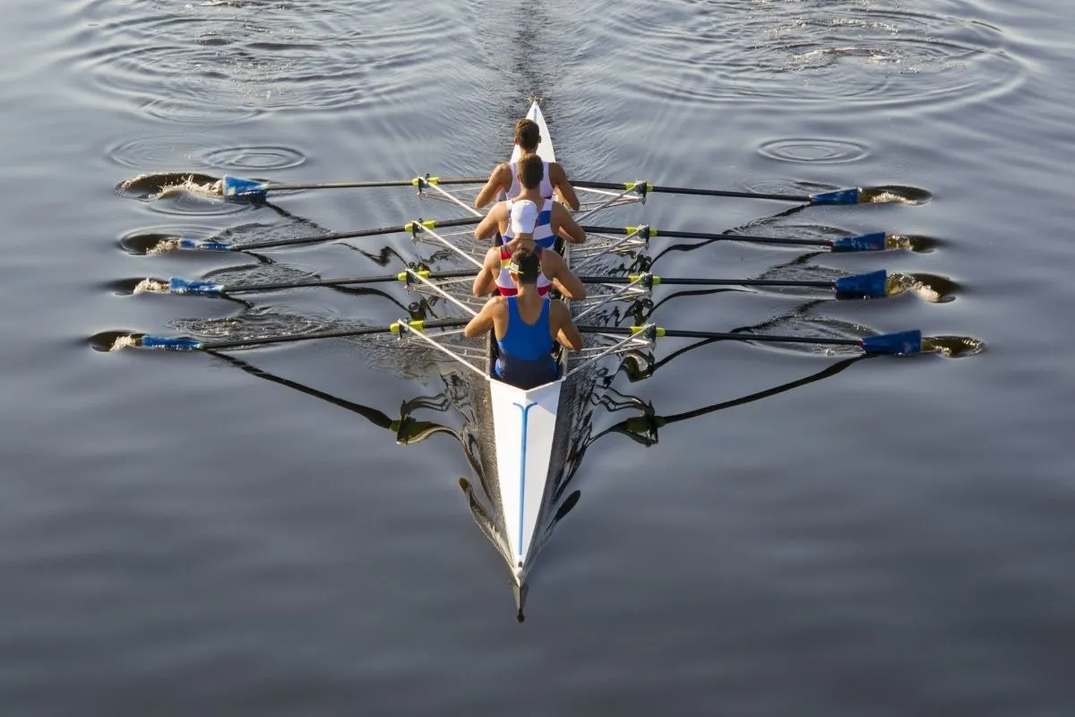 A photo men rowers in lake.