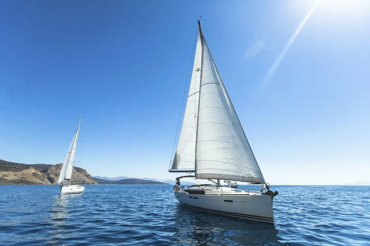 A white sailing yacht on the blue sea.