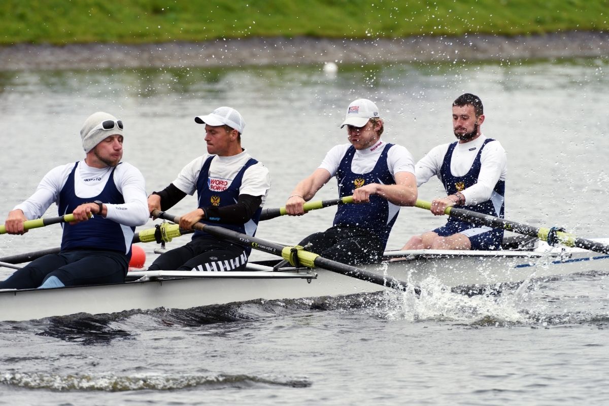 A photo of four men rowing.