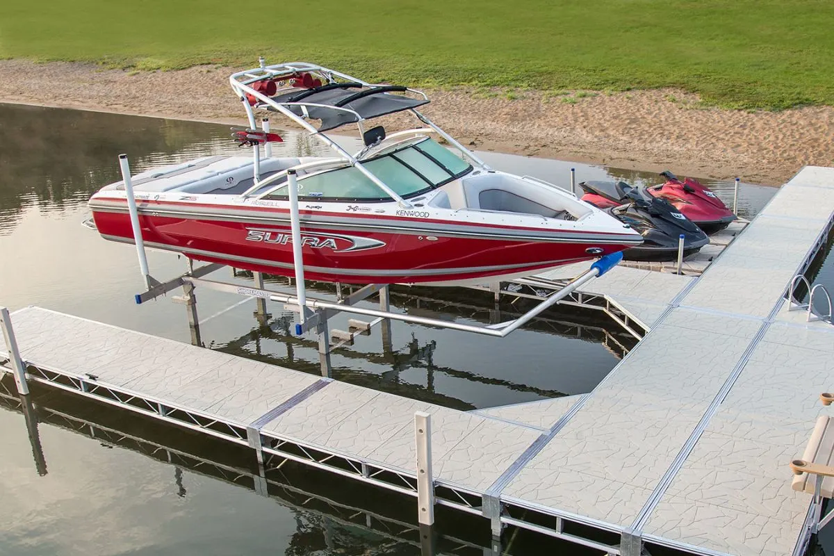 Top and side view of boat being lifted by hydraulic lifts from river.