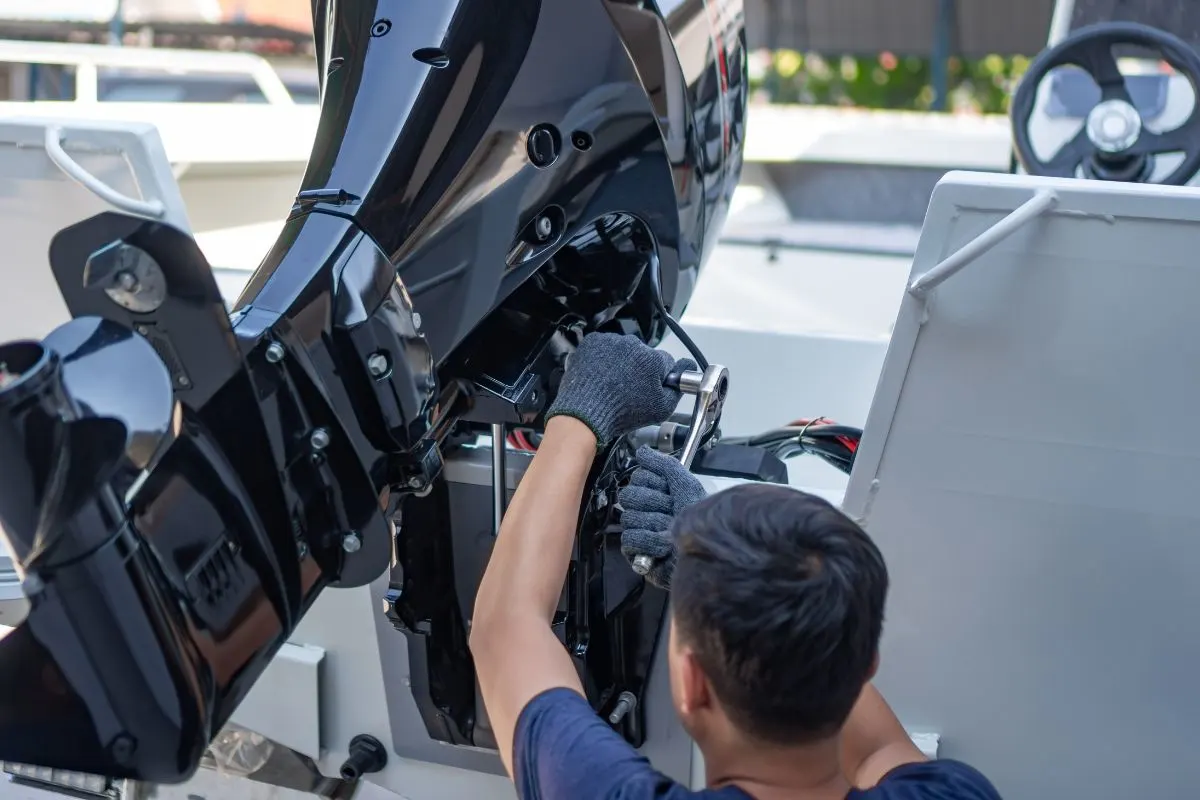 A mechanic is installing speed boat engine.