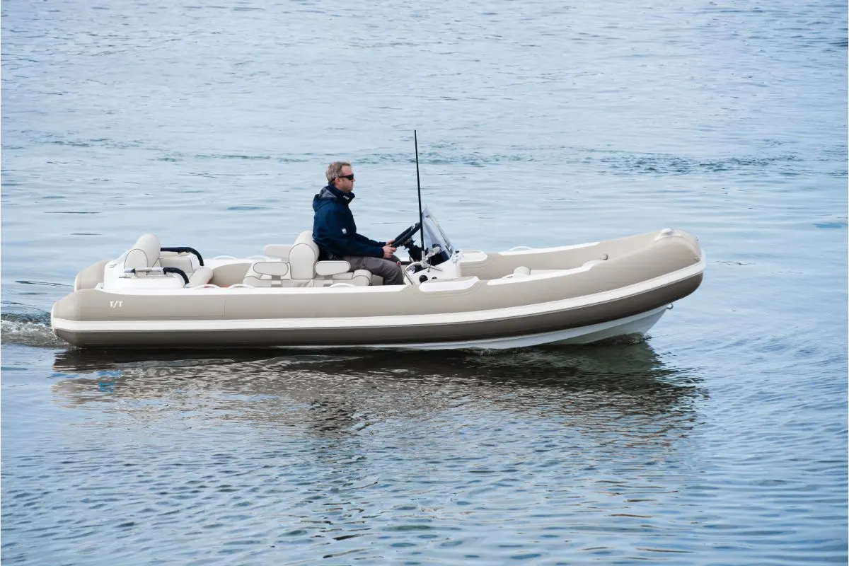 A caucasian male superyacht deckhand doing tender driving on turbo jet boat in port.