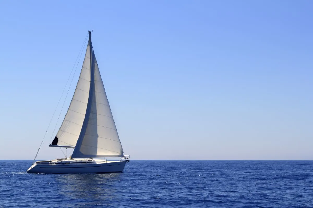 A photo of boat sailing at the blue sea in the morning. 