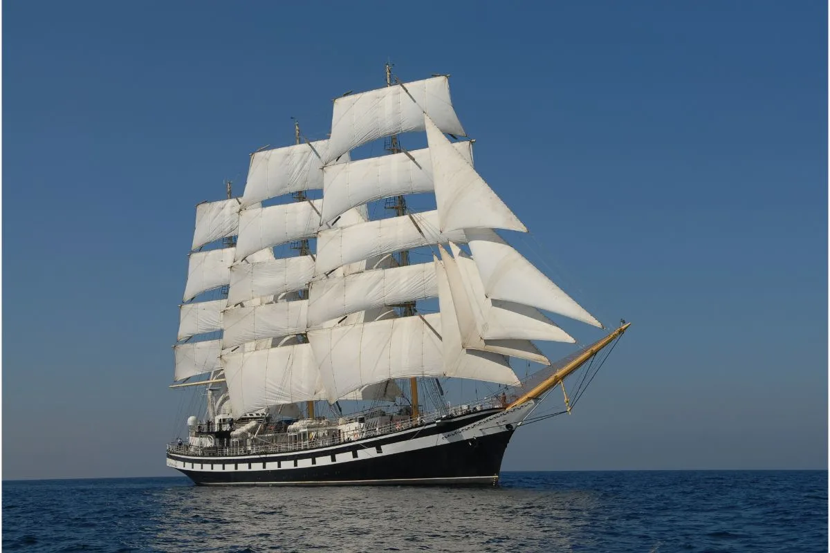 Side view photo of sailing ship under full sail.