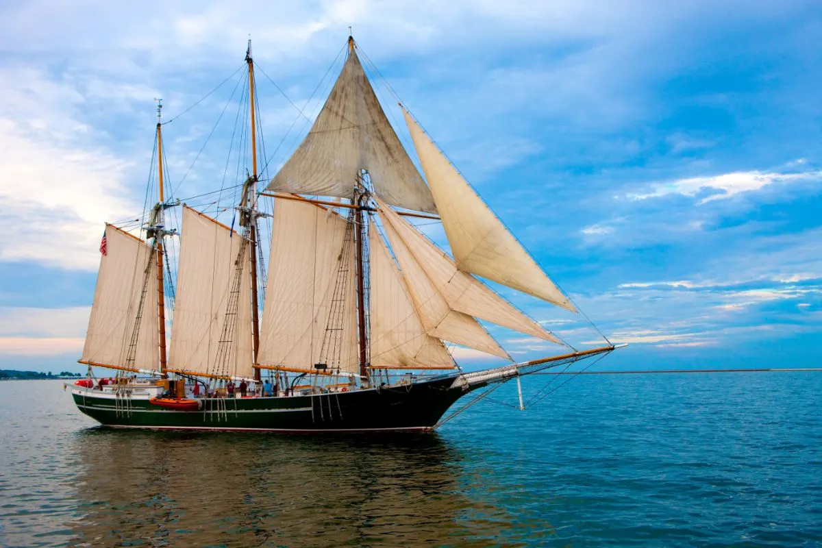 A photo of old style topsail boat at the sea.