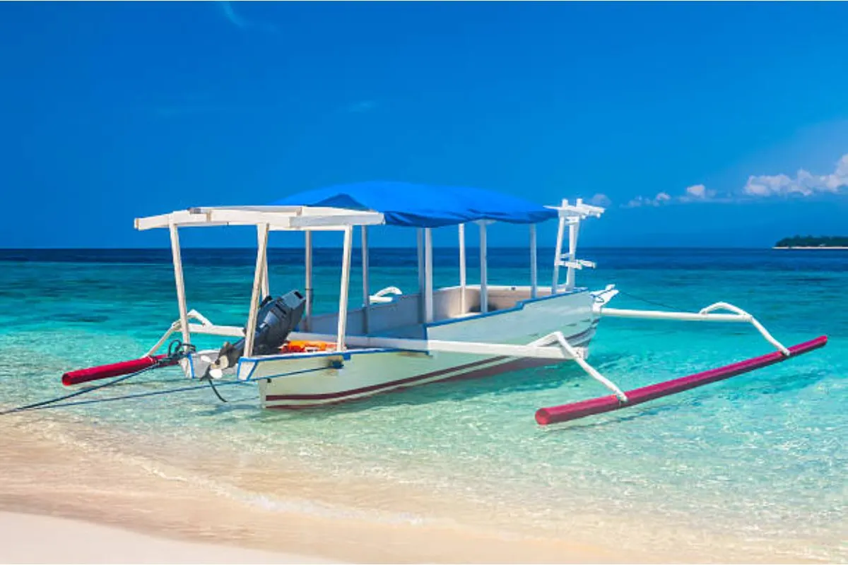 A trimaran boat anchored in the clean and clear seashore located in Coron Palawan.