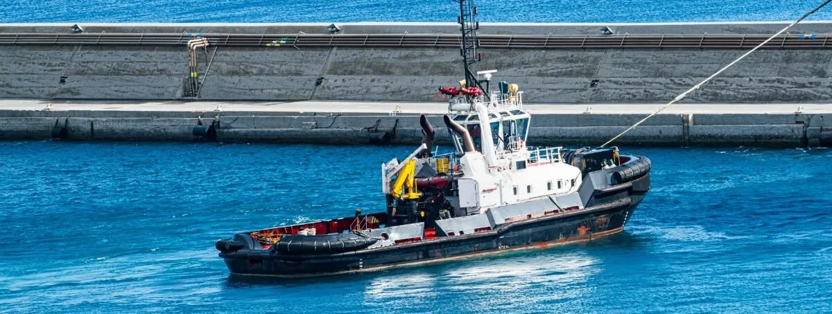 A far view of a ship with corner fenders in front.