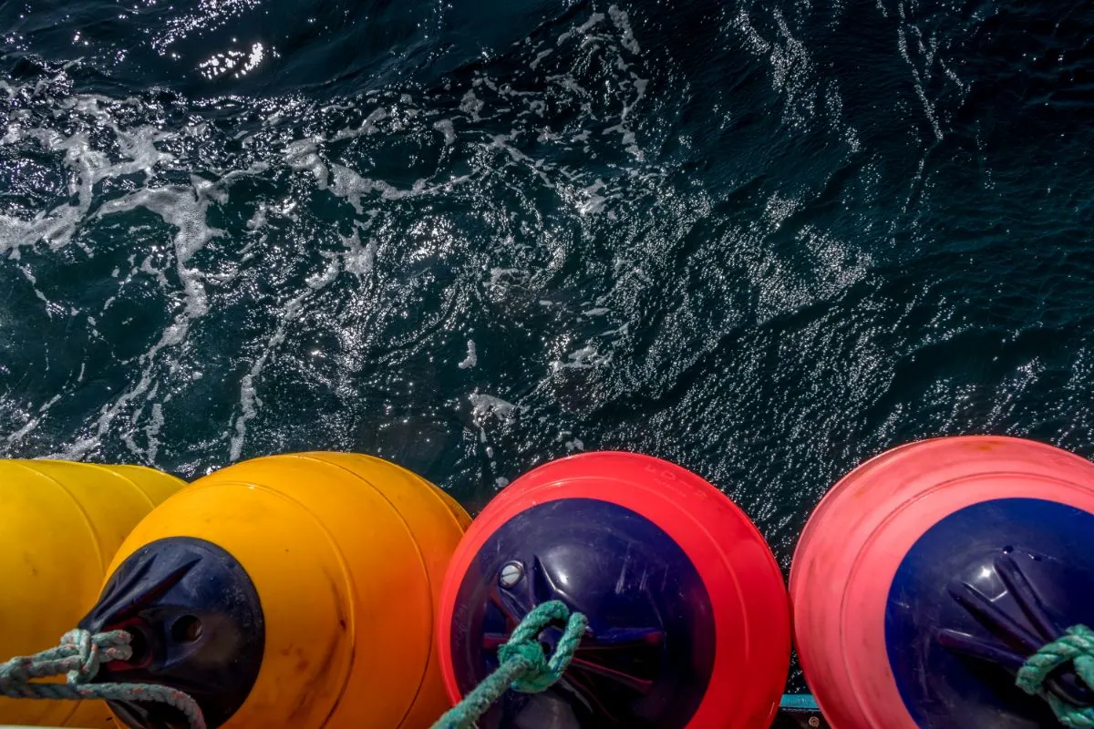 Colorful cone-shaped boat fenders over the sea.