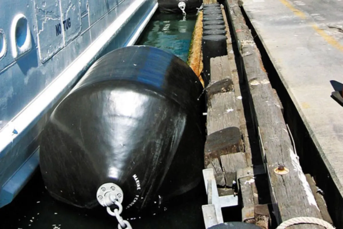 Close up photo of black foam elastomer fender at the side of boat.