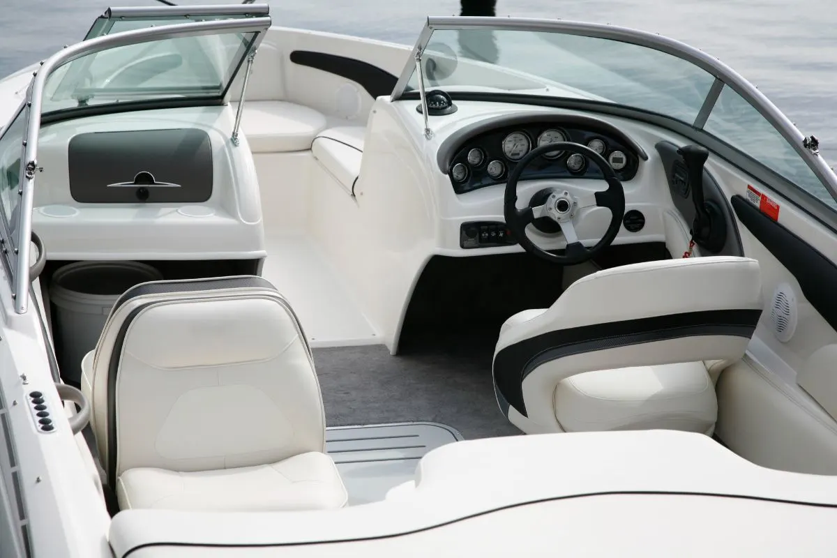 A cockpit of a speedboat with front seat and controller navigations.