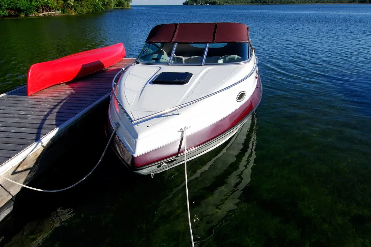 Cabin cruiser boat tied up at the cottage dock on lake.