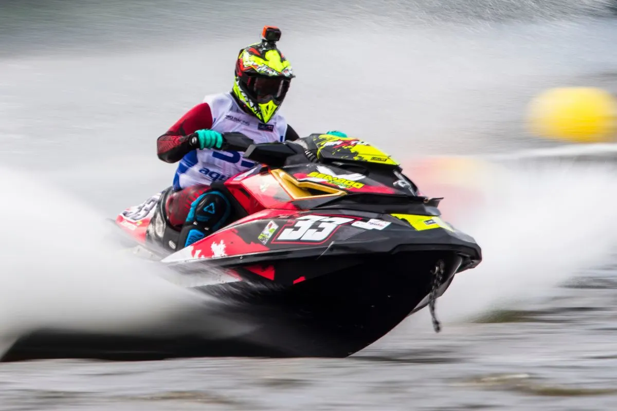 Front view of a man riding a jetski on waves.