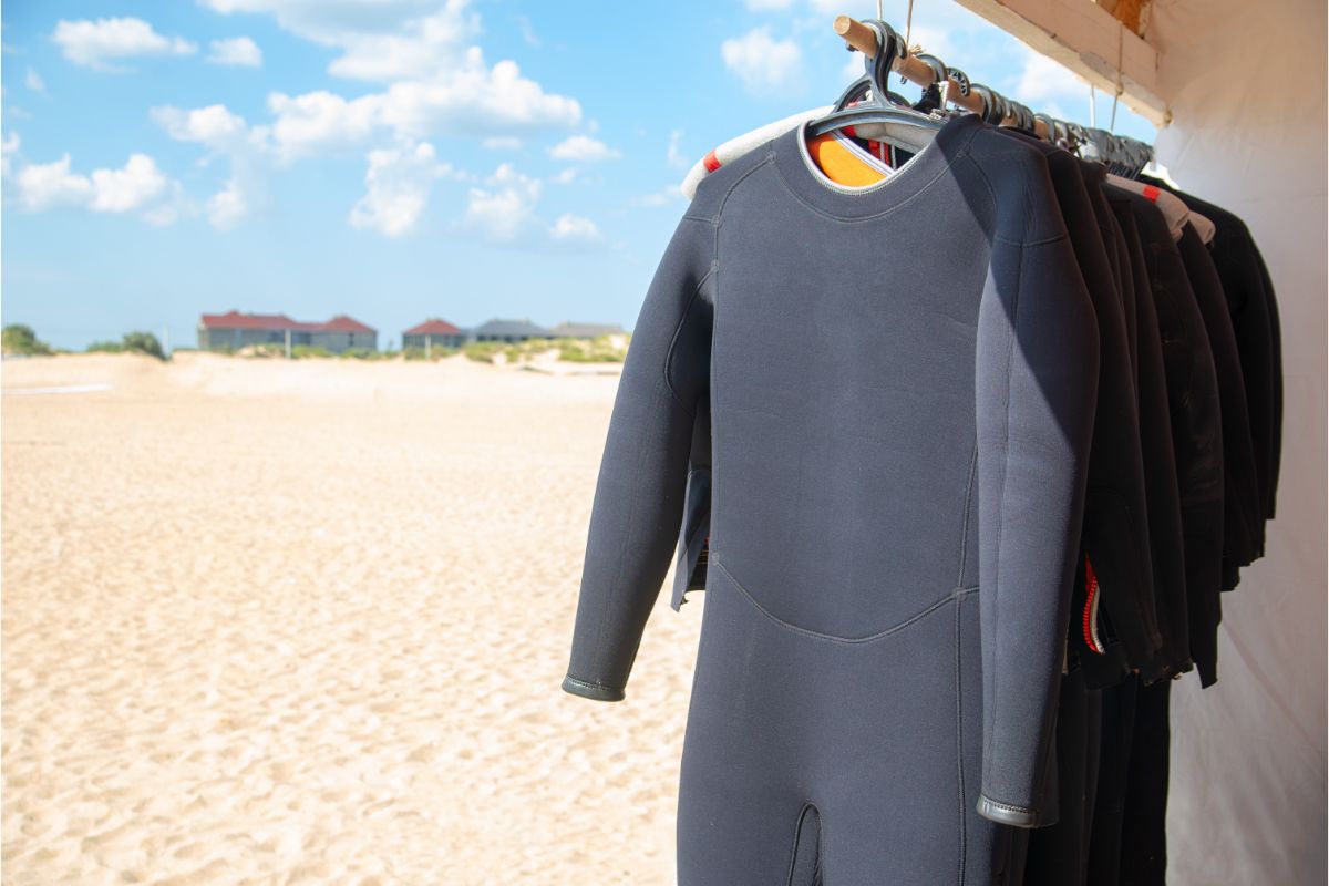 A wetsuits being hanged in a open area in a searshore.