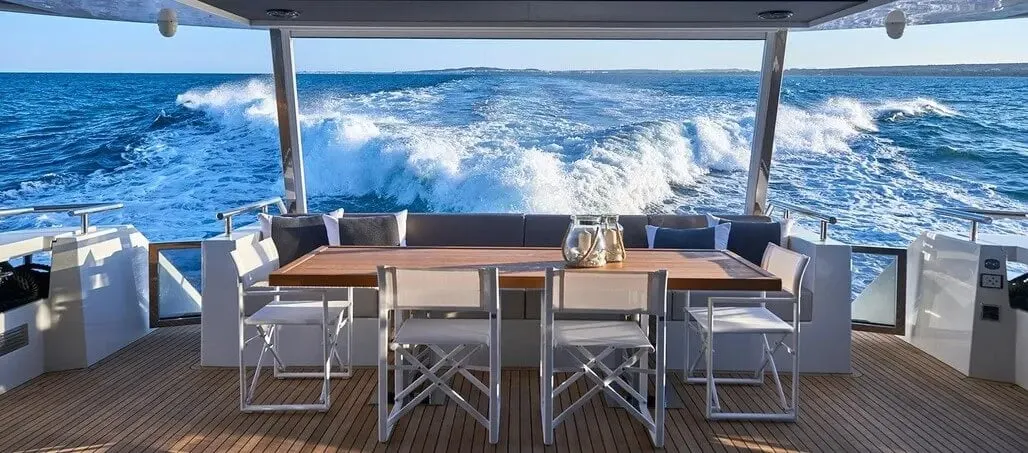 Dinette with a wood-top table surrounded by white chairs and a banquette.