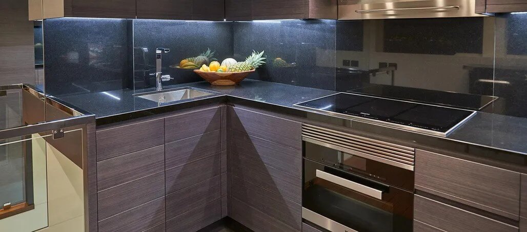 Galley with granite countertops and a built-in cooktop.