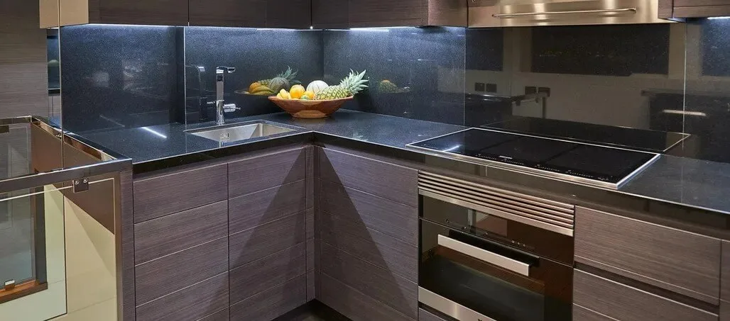 Galley with granite countertops and a built-in cooktop.