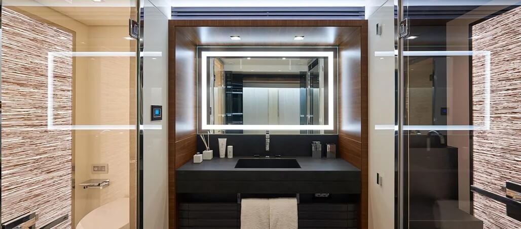 Primary bathroom with a sink vanity flanked by toilet and shower rooms.